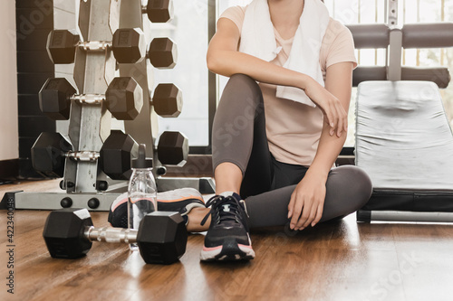 Fototapeta Naklejka Na Ścianę i Meble -  Workout asian woman, girl sitting relax after strength training, exercise with dumbbell in fit sportswear. Sport strong person in gym fitness for healthy lifestyle, recreation concept.