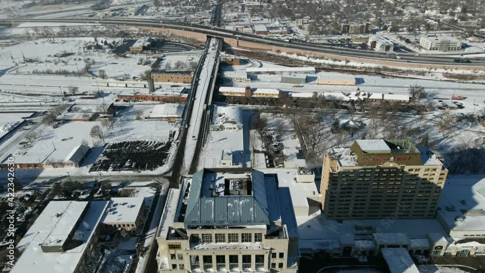 Aerial view Descending shot, Scenic view of cars moving along the highway in Downtown Colorado snow covered streets in the background. Aerial view Descending shot, Scenic view of cars moving along the highway in Downtown Colorado snow covered streets in the background.
