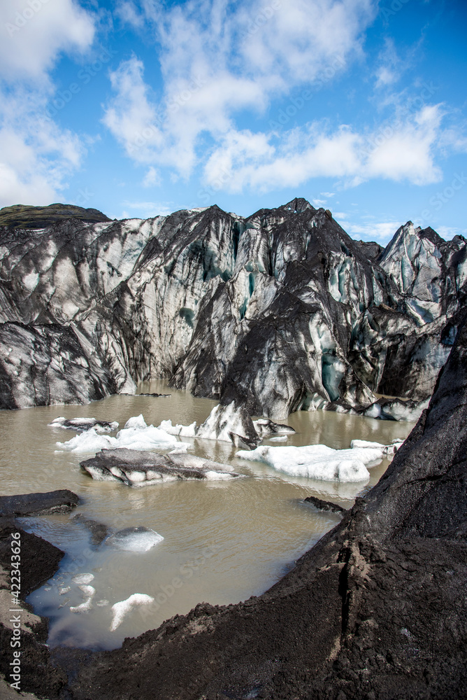 Charming beautiful scenery with nice ice blocks and glacier in volcanic soot in Solheimajokull lagune, Iceland. Exotic countries. Amazing places. Popular tourist atraction. (global warming – concept)