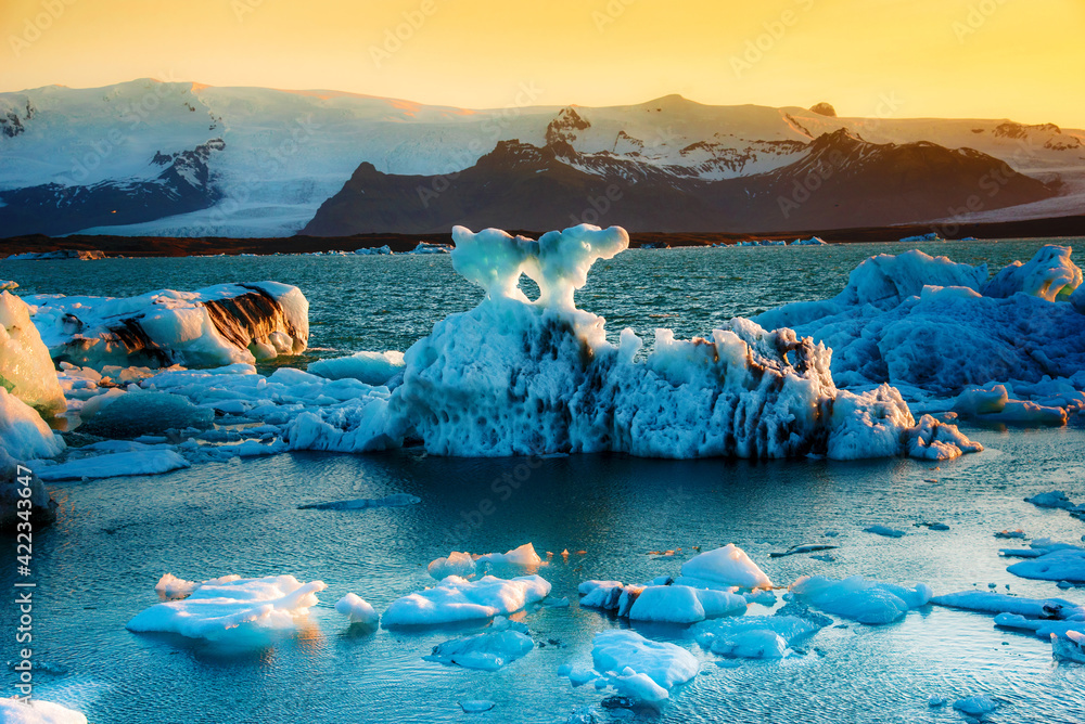 Magical landscape with ice deep in the form of a shark in the famous Jokulsarlon glacial lagoon in Iceland at sunset. Exotic amazing places. Popular tourist atraction. (global warming – concept)