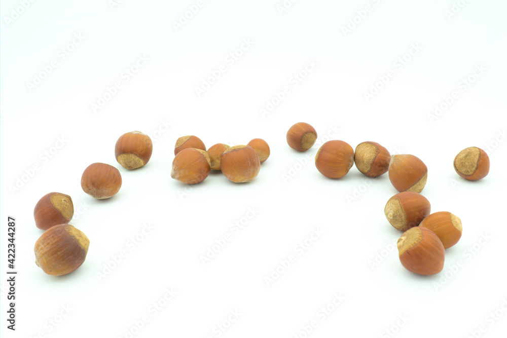 A group of scattered hazelnuts with an empty space in the center A group of scattered hazelnuts with an empty space in the center
