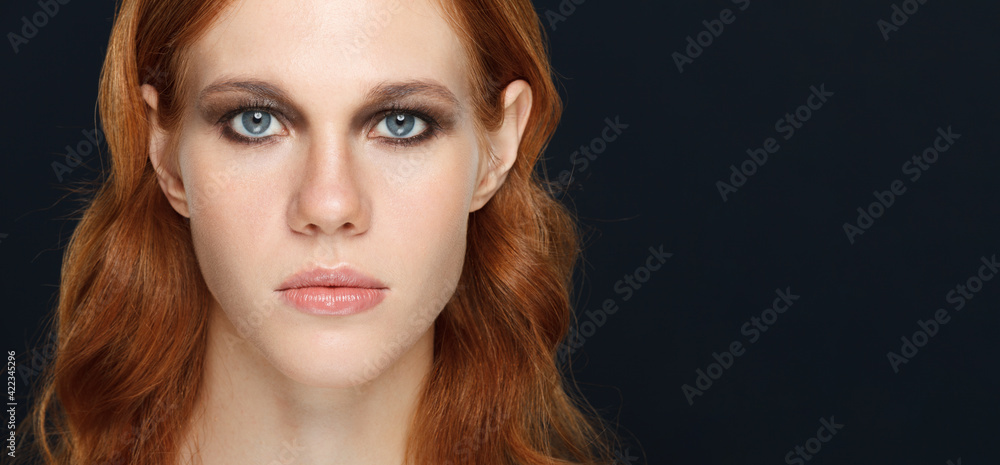 Fototapeta premium Woman portrait with serious emotion over dark background