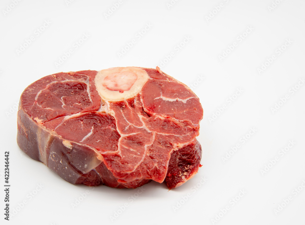 A piece of raw meat with a bone on a white background.