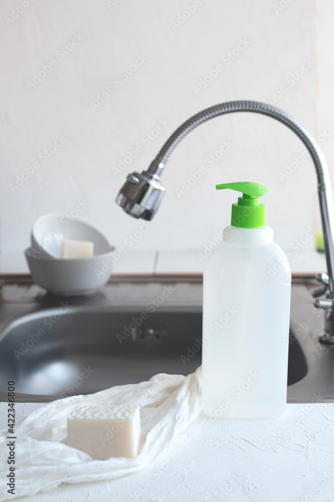Dishwashing detergent, clean bowls, soap, and a kitchen sink Dishwashing detergent, clean bowls, soap, and a kitchen sink