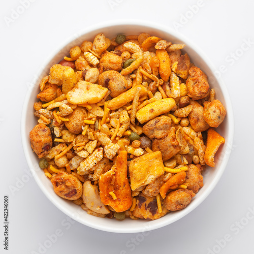 Close-Up of Indian spicy snacks (Namkeen) - (All in one) in a white Ceramic bowl, made with fried peanut, corn flakes, sweet pea, pulses, cashew nuts. Top View