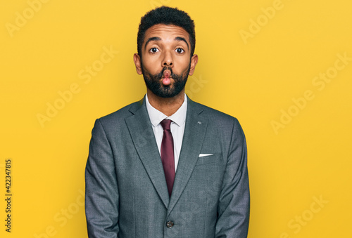 Young african american man wearing business clothes making fish face with lips, crazy and comical gesture. funny expression.
