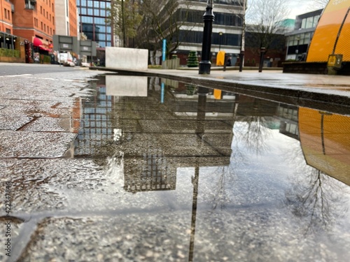 City street with reflections in the puddle of water. Taken in Manchester England. 