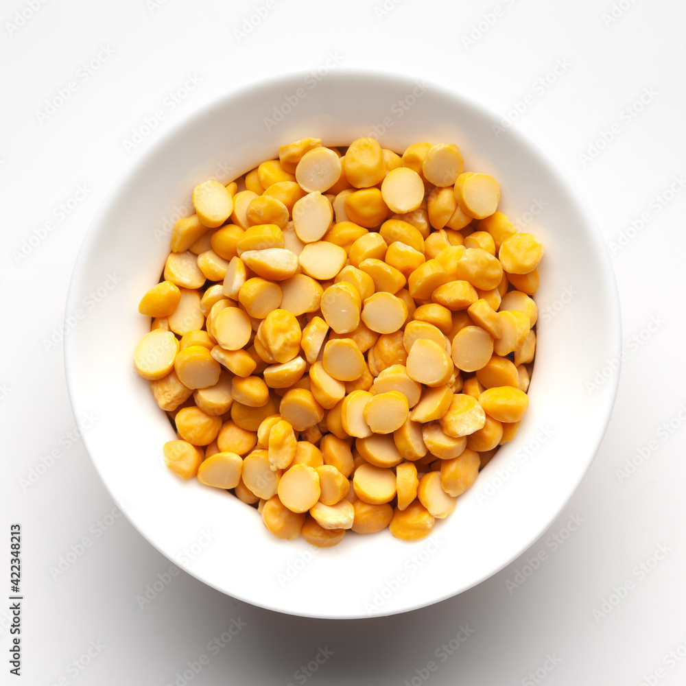 Macro Close-up of Organic Bengal Gram (Cicer arietinum) or split yellow chana dal inside a ceramic white bowl. Top view Macro Close-up of Organic Bengal Gram (Cicer arietinum) or split yellow chana dal inside a ceramic white bowl. Top view