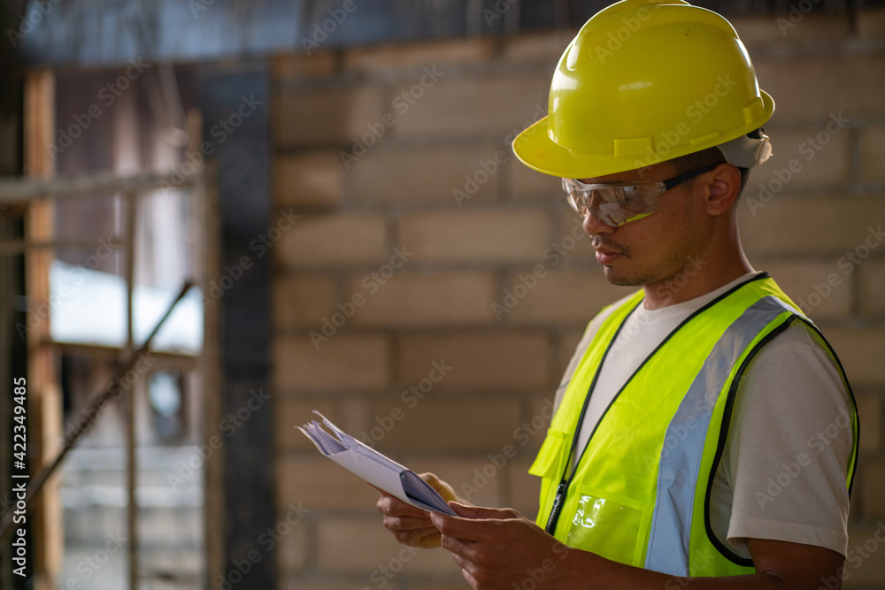 Fototapeta premium Foreman working in modern house building with notebook