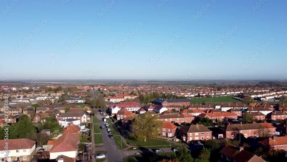 Aerial rising boom shot showing the landscape over a countryside village in southeast England, bright blue sky day. Aerial rising boom shot showing the landscape over a countryside village in southeast England, bright blue sky day.