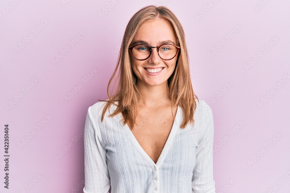 Beautiful blonde woman wearing casual clothes and glasses with a happy and cool smile on face. lucky person.