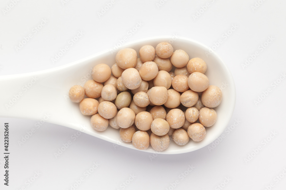 Macro Close up of Close up of Organic dry peas whole (Pisum sativum) or matar dal on a white ceramic soup spoon. Top view Macro Close up of Close up of Organic dry peas whole (Pisum sativum) or matar dal on a white ceramic soup spoon. Top view