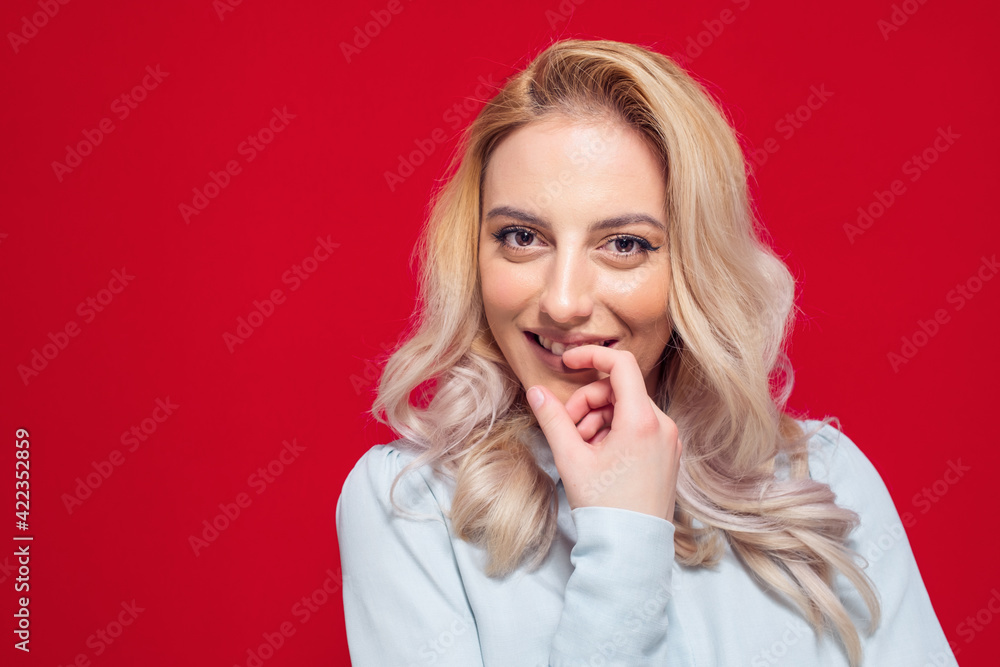 Charming closeup smiling young woman with her fingers on lips. Smile expression face of cute girl, isolated on white background Charming closeup smiling young woman with her fingers on lips. Smile expression face of cute girl, isolated on white background