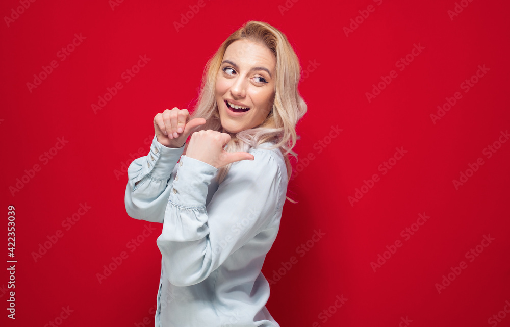 Woman pointing to blank space, presenting your product or something, isolated on red background. Promoter girl Woman pointing to blank space, presenting your product or something, isolated on red background. Promoter girl