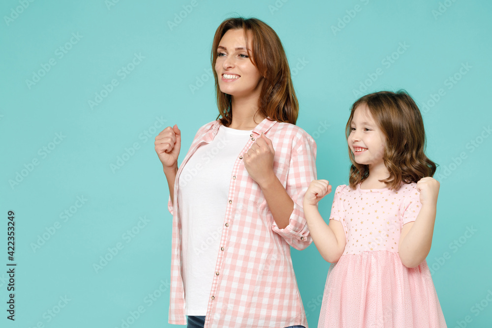 Happy woman in pink clothes have fun child baby girl 5-6 years old. Mommy little kid daughter doing winner gesture celebrate isolated on pastel blue background studio Mother's Day love family concept Happy woman in pink clothes have fun child baby girl 5-6 years old. Mommy little kid daughter doing winner gesture celebrate isolated on pastel blue background studio Mother's Day love family concept