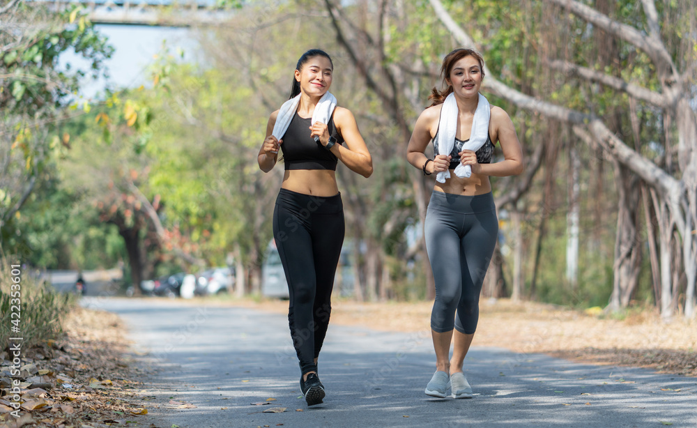 Obraz premium Happy young asian women in sportswear jogging and running outdoor. Lifestyle healthcare concept