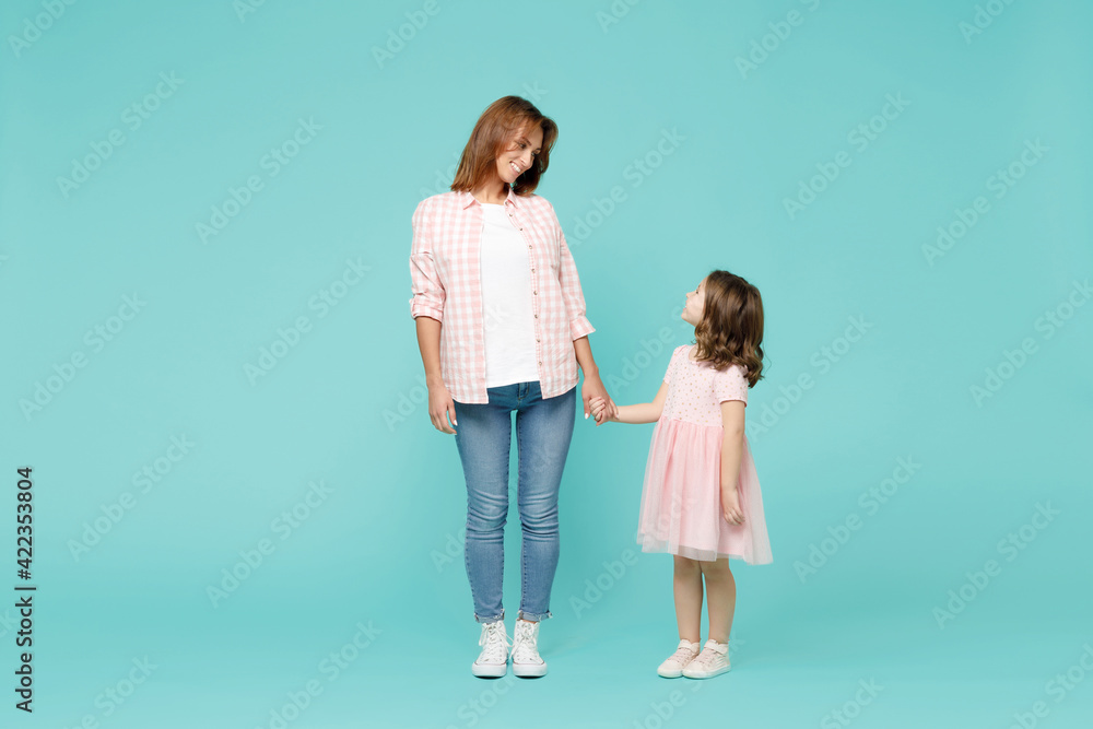 Full length happy woman in pink clothes have fun with cute child baby girl 5-6 years old. Mommy little kid daughter isolated on pastel blue azure background studio. Mother's Day love family concept. Full length happy woman in pink clothes have fun with cute child baby girl 5-6 years old. Mommy little kid daughter isolated on pastel blue azure background studio. Mother's Day love family concept.