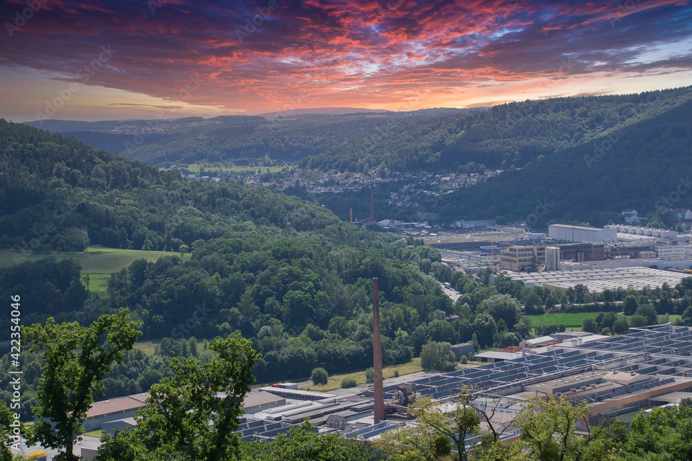 modern city with sunset- sky in green mountains