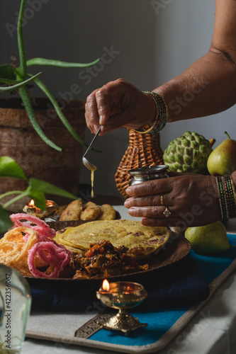 Woman pouring ghee over traditional festive food