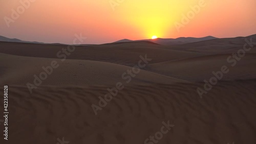 Landscape of desert dunes at sunset on a windy day