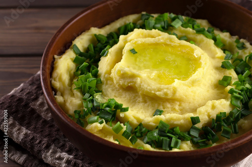 Champ is an Irish dish. Mashed potatoes with green onions. Wooden background.