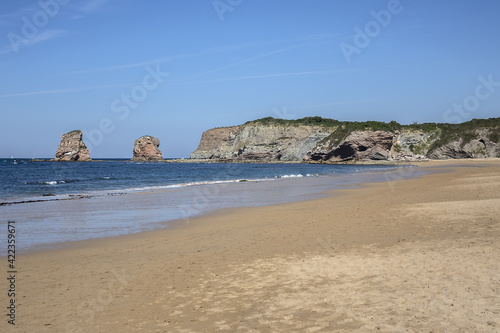 3 km long, the longest beach in the Basque Country is in Hendaye. Two-twins (Les Deux-Jumeaux) at Cape Sainte-Anne on the background. Hendaye, Basque Country coast, Pyrenees Atlantiques, France,