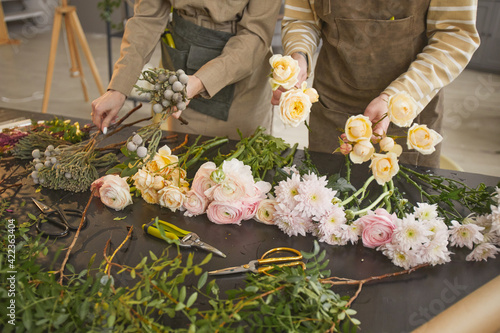 фотографія Background image of beautiful flowers on table in flower shop with two unrecogni