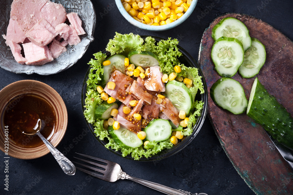 fresh tuna salad with corn and lettuce leaves, sauce and fresh cucumbers, flatlay fresh tuna salad with corn and lettuce leaves, sauce and fresh cucumbers, flatlay
