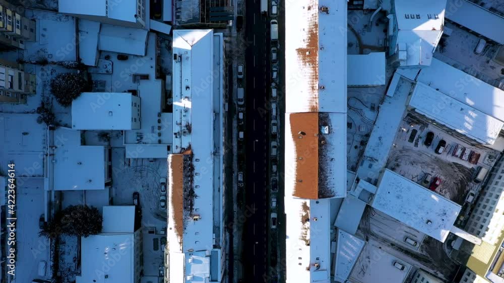Aerial top down view of beautiful city center with red tile roofs, street and traffic covered in snow during winter in Stuttgart, Germany. Aerial top down view of beautiful city center with red tile roofs, street and traffic covered in snow during winter in Stuttgart, Germany.