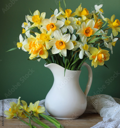 bouquet of yellow daffodils in a white jug.