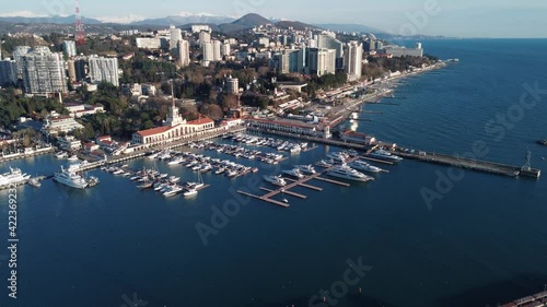 Port with vessels of Sochi city on sea coast against hills photo