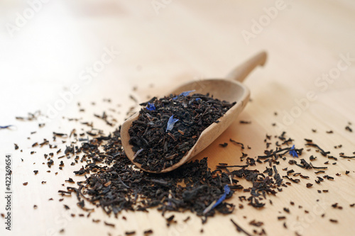 Black tea Earl Grey Ceylon Darjeeling on wooden shovel scoop closeup