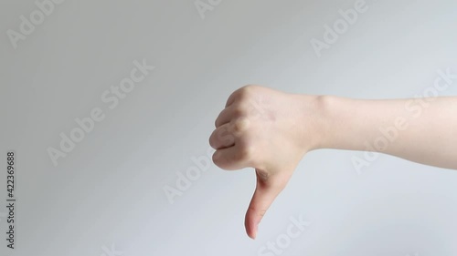 Hand gestures. Approval dislike. Woman showing thumb up down isolated on gray copyspace background.