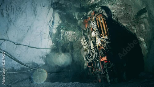 Boring machine is drilling ground in the mine. Underground development, underground extraction, underground mining operations. photo