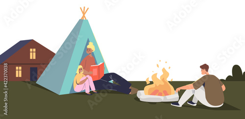 Family camping on backyard outside house. Happy kids and parents around camp tent and fire together