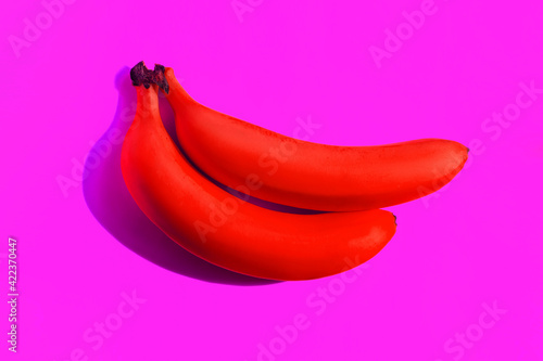 Fotografie Two ripe red bananas cast a shadow isolated on a bright purple background
