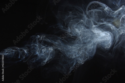 Abstract wisps of smoke on a black background.