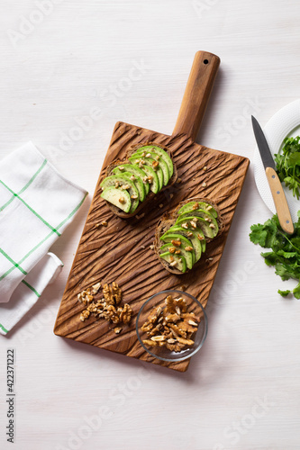 Sliced avocado on toast bread with nuts. Breakfast and healthy food concept. Top view.