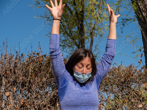 BRUNETTE WOMAN DOING YOGA IN PARK