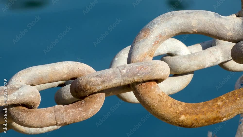 Close up of rusty chains in port of Blanes against blue water background. Static Close up of rusty chains in port of Blanes against blue water background. Static