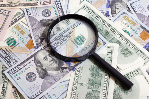 Magnifying glass on the background of bundle dollars - texture, background