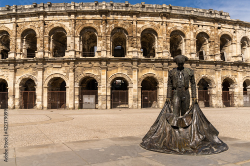 view of the Roman amphitheater in Nimes with the statue of the bullfighter Nimeno photo