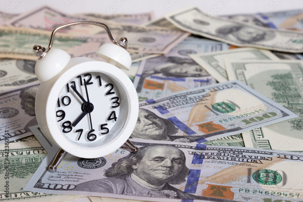 Clock on the background of bundle of dollars - texture, background Clock on the background of bundle of dollars - texture, background