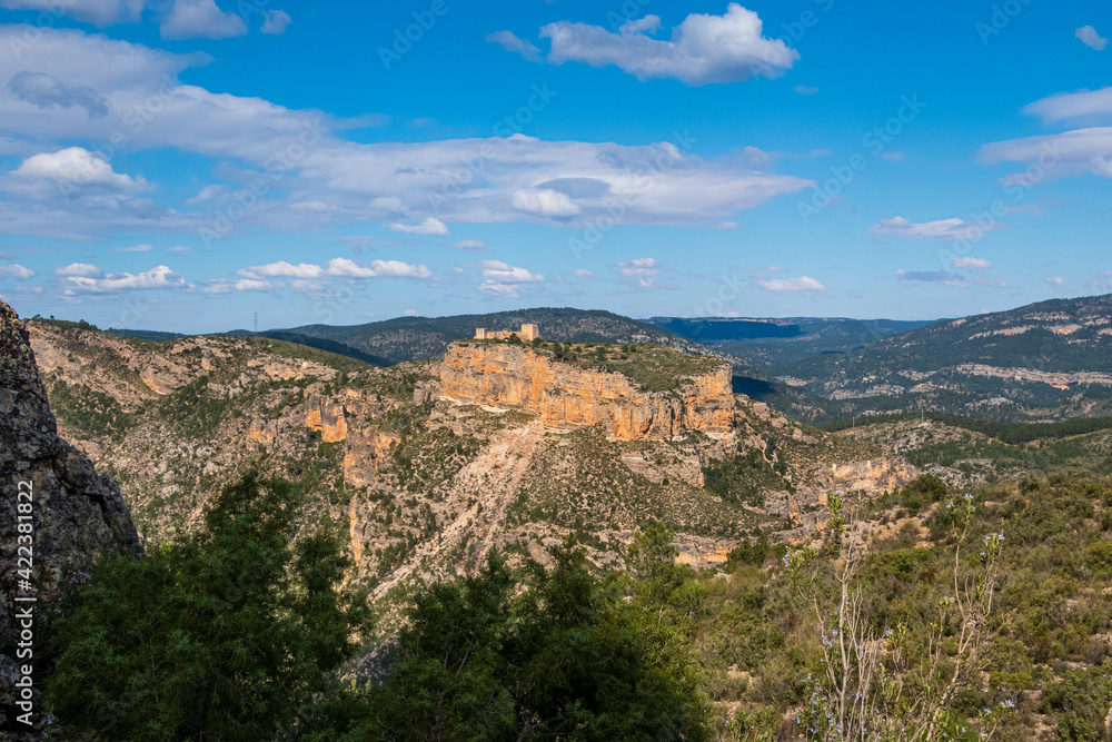 Natural environment of Cortes de pallás, in Valencia (Spain), with views of its mountains, Chirel Castle and its coniferous forests. On a sunny and cloudy day.