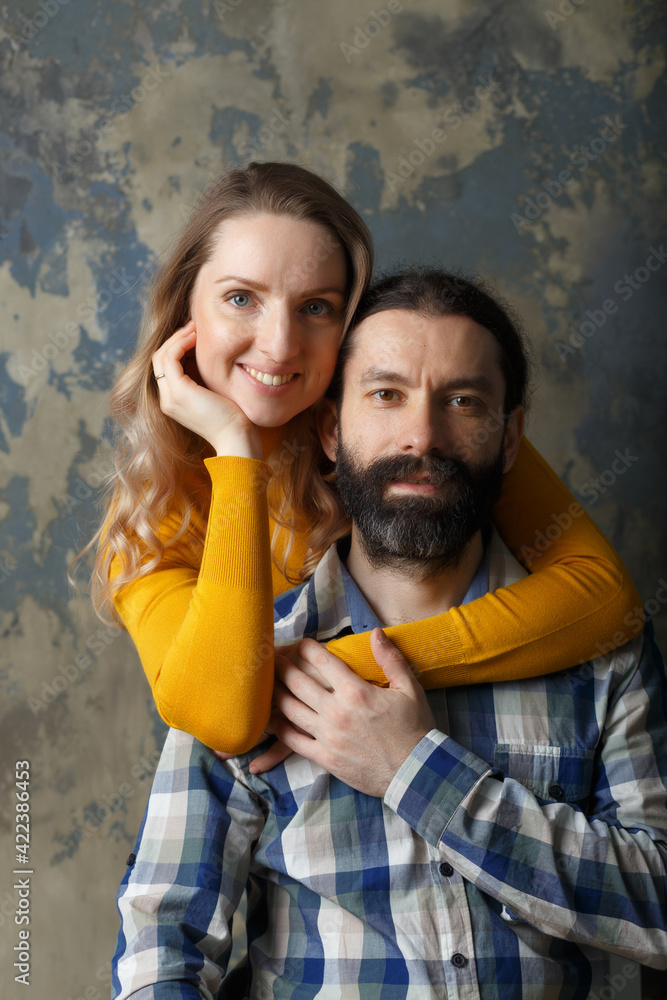 Obraz premium Happy adult couple hugging, smiling wide and looking at camera