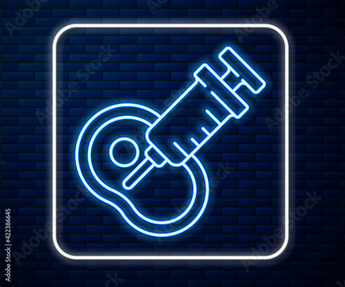 Glowing neon line Genetically modified meat icon isolated on brick wall background. Syringe being injected to meat. Vector