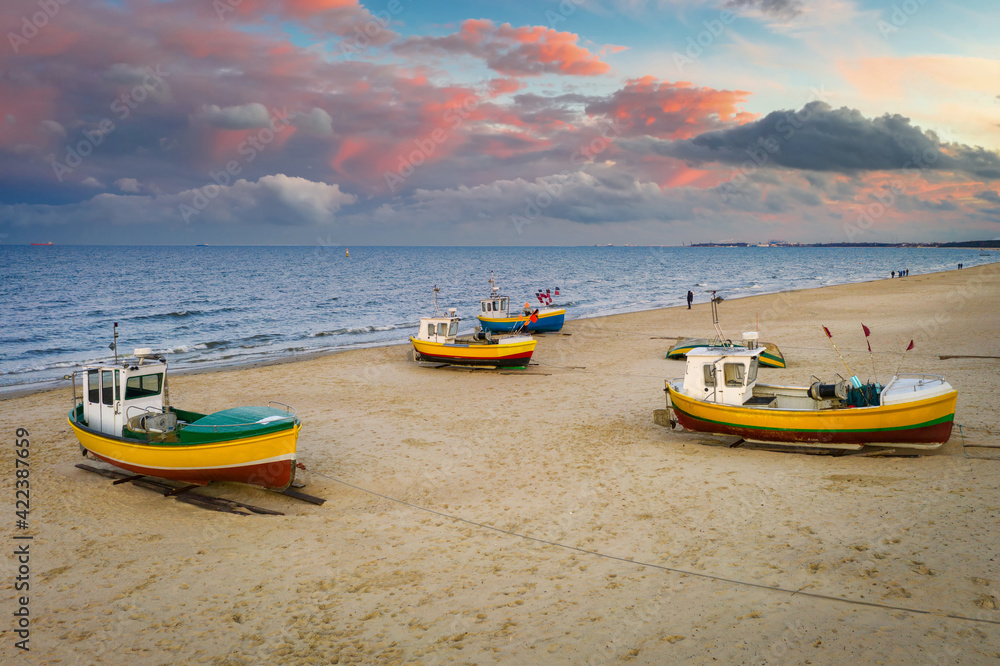 Amazing sunset with fishing boats at the beach of Baltic Sea in Sopot, Poland