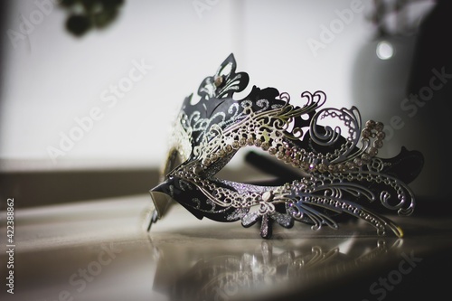 A portrait of a mysterious venetian mask lit by a window. A great way to hide your identity on a masked ball, carnival or halloween party.