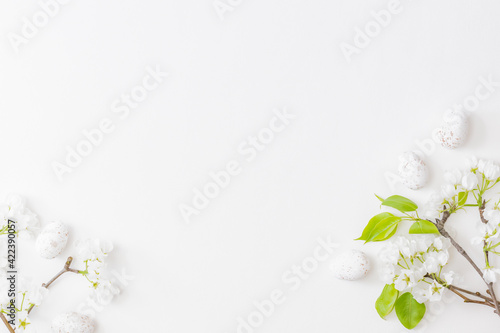 Flat lay easter frame with spring flowers and eggs on white background
