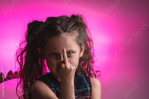 portrait of a little girl showing the middle finger